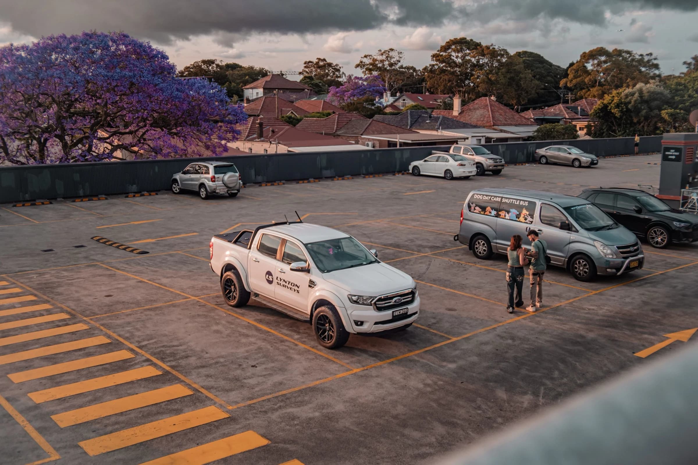 White tradie ute parked on a rooftop car park at sunset