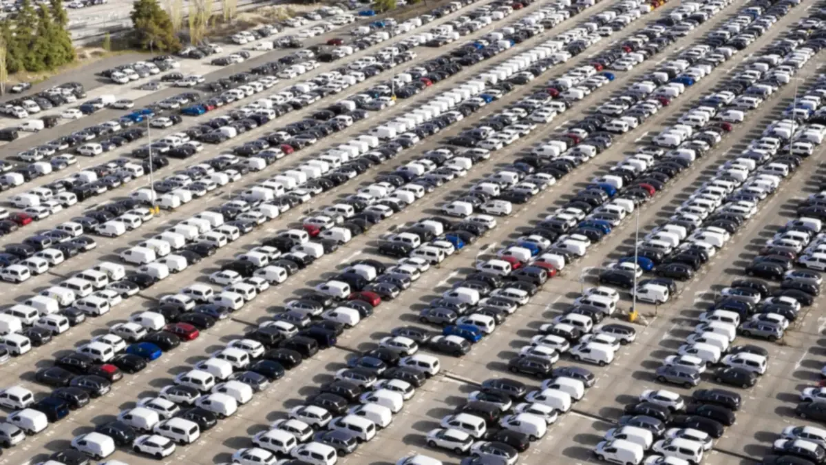 Aerial view of cars parked in long rows at a vehicle yard