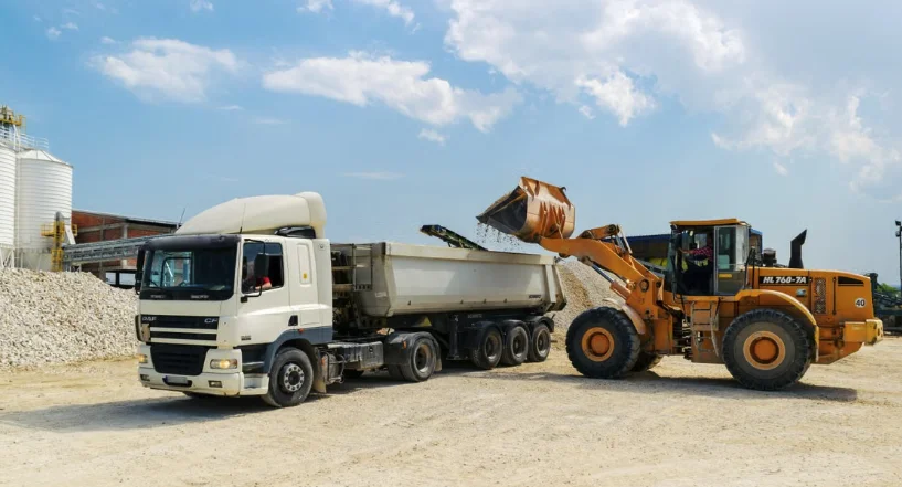 Wheel loader filling a tipper truck with gravel at a quarry